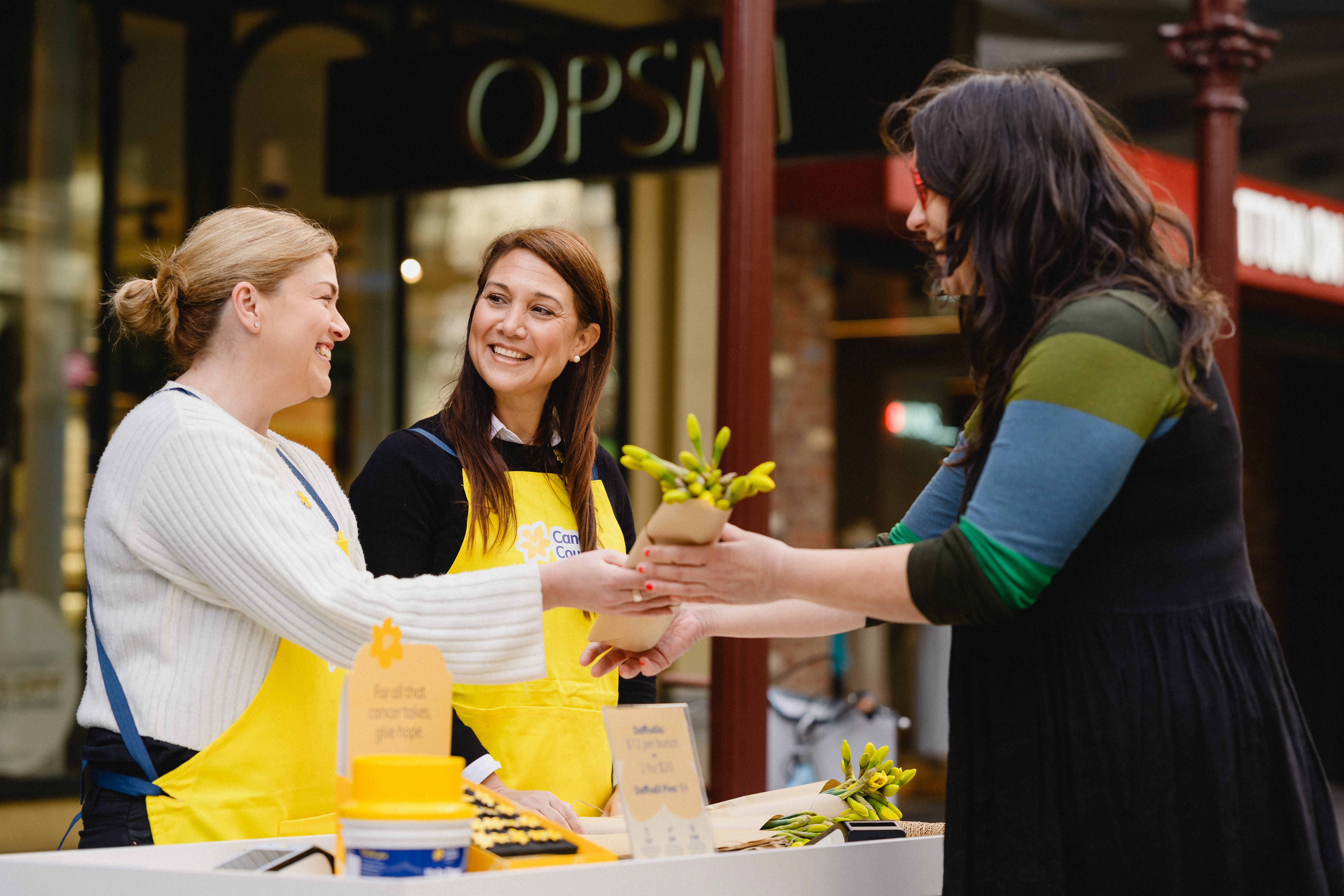 Ladies selling daffodils at a stall