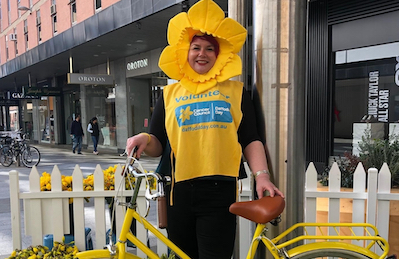 volunteer in daffodil costume with push bike volunteer in daffodil costume with push bike